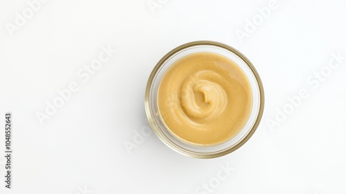 A small bowl of creamy mustard on a white background.