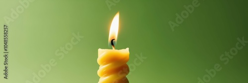 Burning birthday candle, stacked orange slices, green background, minimalist composition, soft lighting, celebration concept, citrus fruit, flame, warm glow, contrast, still life, panoramic view, simp photo