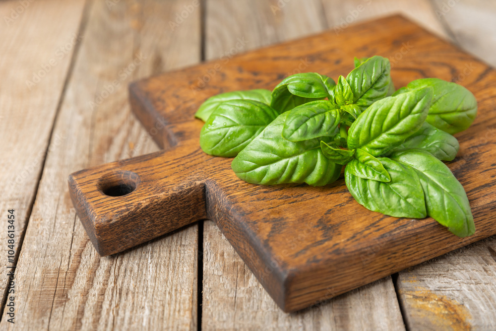 Green basil leaves on a textured wooden background. Kitchen herbs, spices. Fresh green organic basil. Vegan. Greens for salad. Place for text. Copy space. Green basil leaves on a textured wooden background. Kitchen herbs, spices. Fresh green organic basil. Vegan. Greens for salad. Place for text. Copy space.