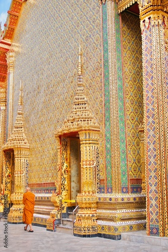 A Thai monk is walking in a beautiful craftsmanship and famous Buddhist temple of Wat Ratchabophit Sathitmahasimaram Ratchaworawihan in Bangkok, Thailand. A symbol of belief and worship in Buddhism photo