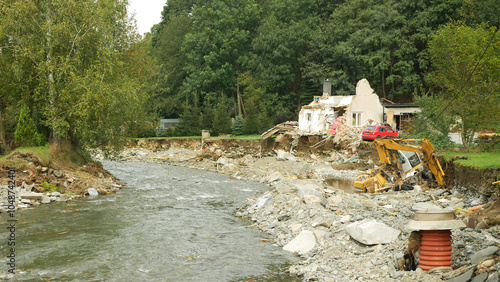 JESENIK, CZECH REPUBLIC, SEPTEMBER 21, 2024: Czech flood after house destroyed river swept Bela Jesenik flooded damaged building water debris excavator buried digger mud people rain villages cars photo