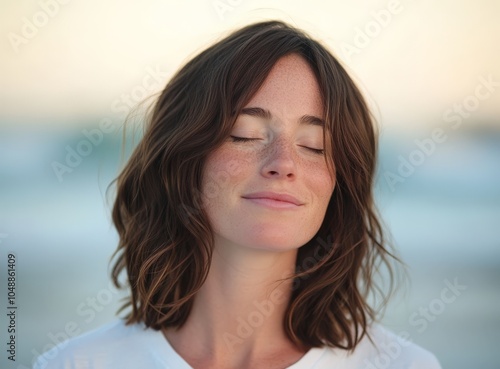 Serene young woman enjoying a tranquil moment by the ocean at sunset