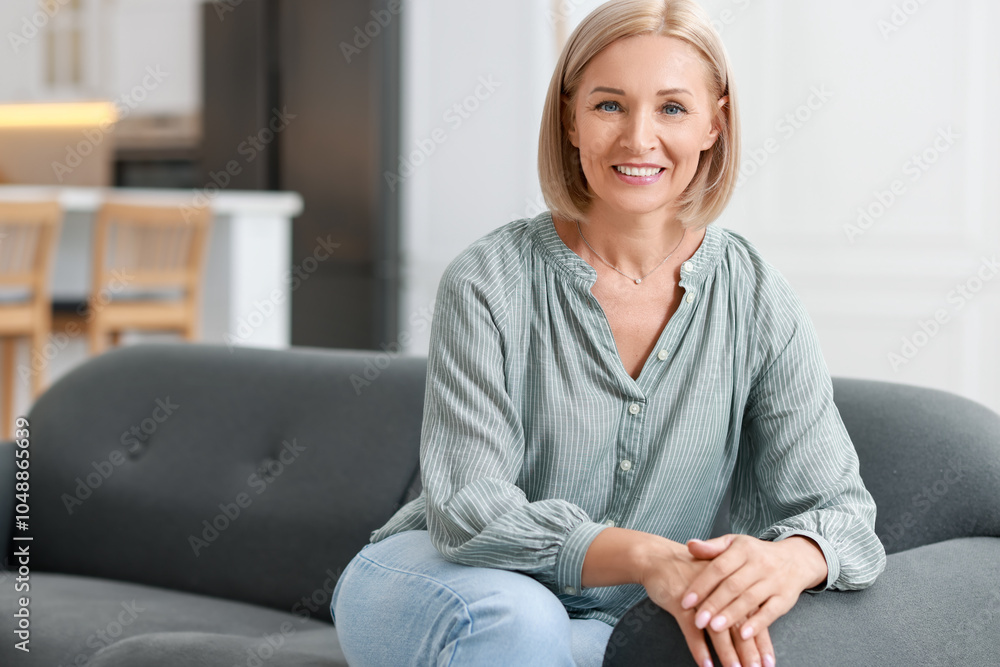 Happy middle aged woman on sofa indoors, space for text Happy middle aged woman on sofa indoors, space for text