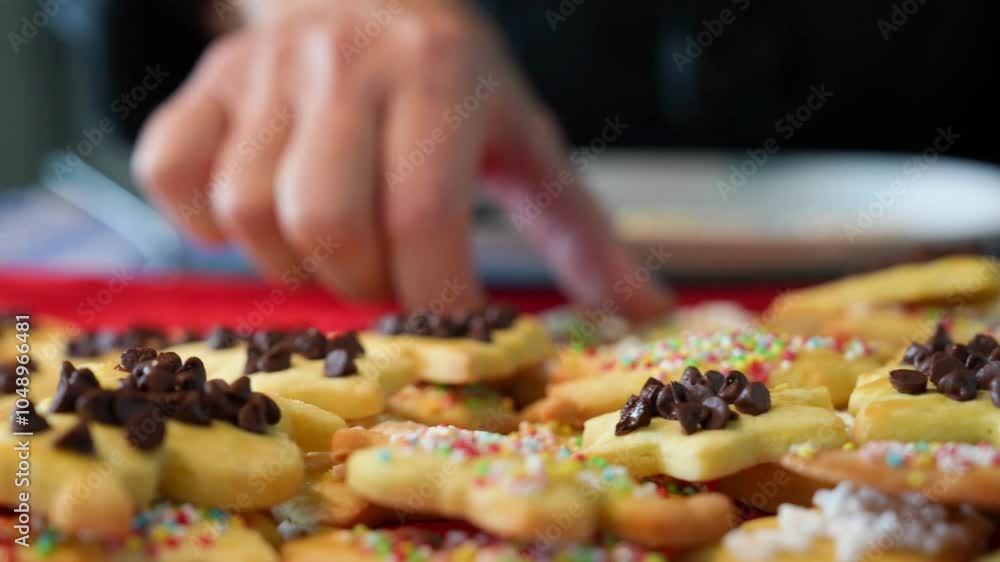 A woman places freshly baked cookies on a tray before serving them A woman places freshly baked cookies on a tray before serving them