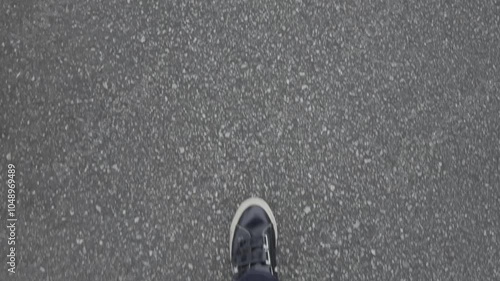 アスファルトの上を歩く足元を写した素材