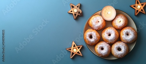 Small donuts dusted with powder are arranged in a saucer accompanied by nine white candles and three wooden stars of David all set against a blue background in a flat lay close up Hanukkah Celebrat photo