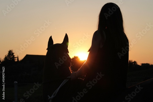 A girl on a horse during sunset 