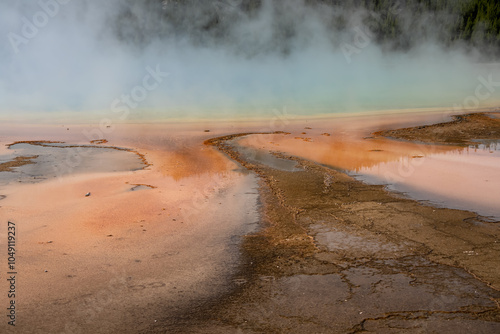 an active geyser spring with an intermittent discharge of water ejected turbulently and accompanied by steam