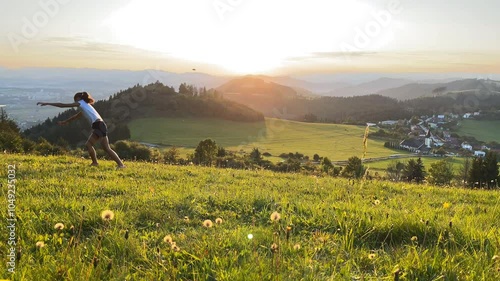 Wallpaper Mural Little girl doing Cartwheel gymnastics sideways rotary movement on green grass hills at sunset time near Zilina town in Slovakia. Happy childhood moments or outdoor time spending concept 4K footage. Torontodigital.ca