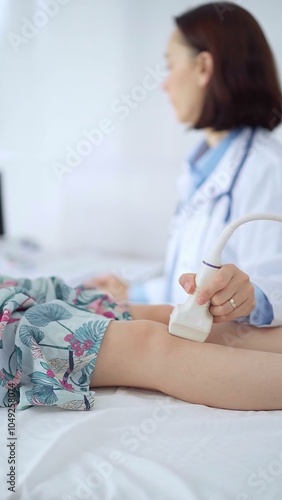 Doctor and kid patient. Orthopedist performing ultrasound examination on a child's knee in a clinic. Medicine and health care photo