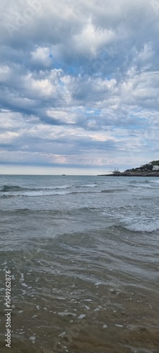 spiaggia sabbiosa all'alba con un antico trabucco in lontananza