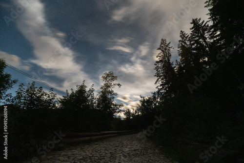 Landscape astrophotography, droga Brata Alberta in Polish mountains in Zakopane. Sky with clouds and stars.