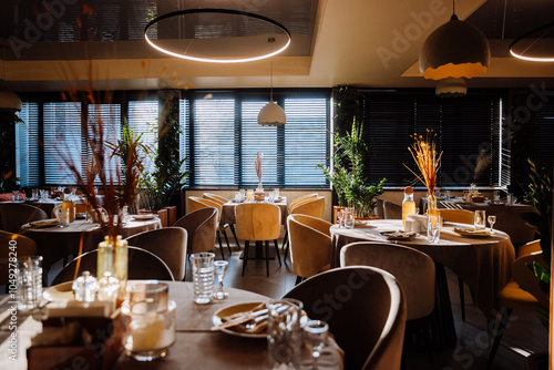Elegant restaurant interior with natural light, cozy decor, and stylish table settings