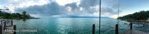 Beautiful panoramic view beach in Ilhabela with pier on tropical island on the Brazilian sea coast during a sunny day of vacation and sightseeing trip.