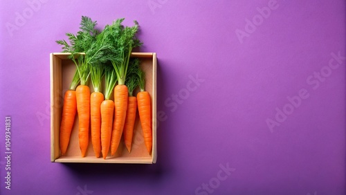 Fresh carrot in orange box on purple background, high angle view