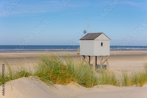 A wooden shelter on high stilts that stands on the North Sea beach (De Drenkelingenhuisje) The Dutch Wadden Sea island Terschelling, Municipality and an island in the northern, Friesland, Netherlands. photo