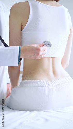 Doctor and patient. Physician is using stethoscope examining woman lungs from the back side. Medicine and health care