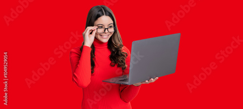 Teen girl with laptop isolated on red. Teen girl study online. Online education. Back to school. Knowledge and online education. Video lesson on laptop. Online courses photo