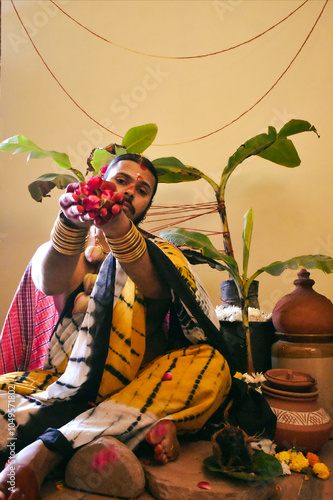 A man in blue and white saree holding red flowers photo