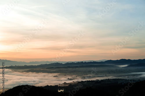 A high-altitude landscape shot showing the morning mist covering the entire city and the sunrise.