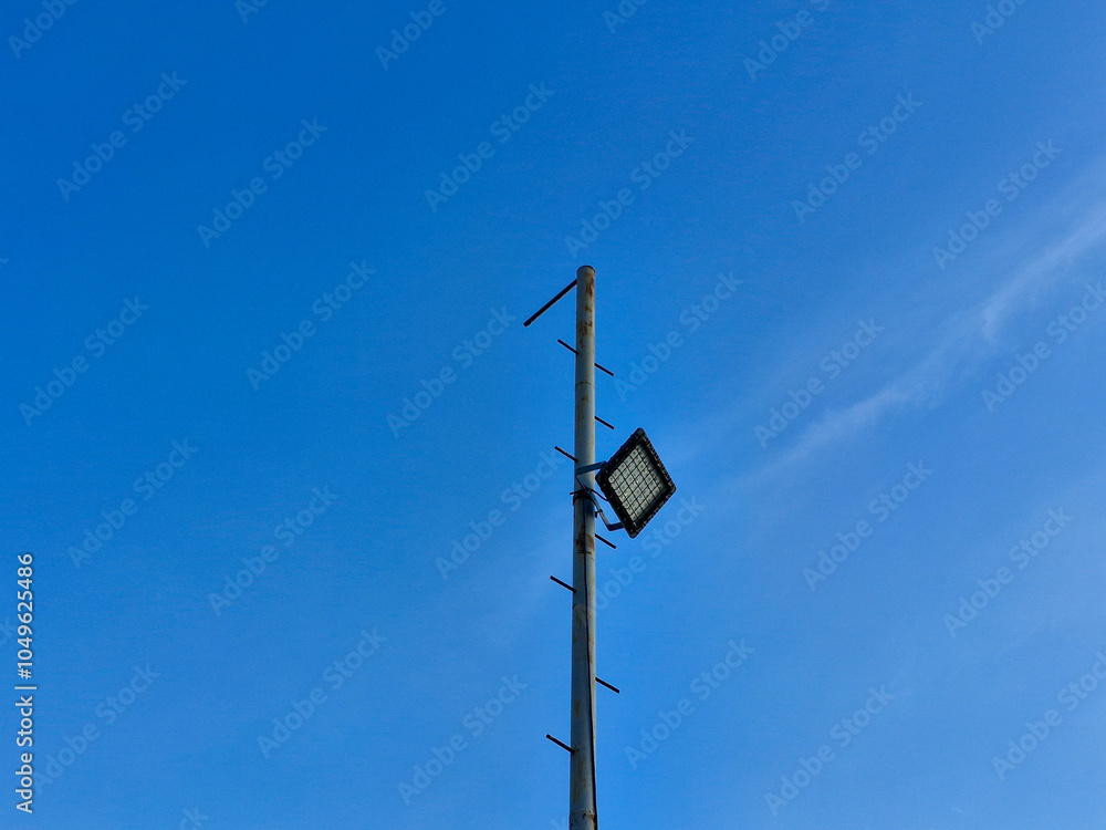 Pole for beach lighting with a bright blue sky background Pole for beach lighting with a bright blue sky background