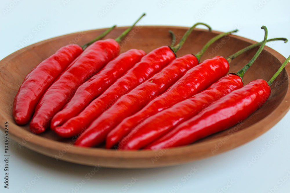 Some fresh big red chili, on wooden plate, isolated on white background Some fresh big red chili, on wooden plate, isolated on white background