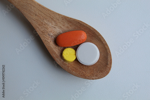 Some medicines on wooden spoon. Isolated on white background, flat lay or top view photo