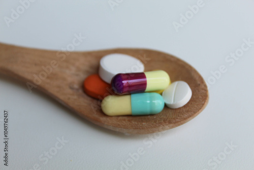 Some medicines on wooden spoon. Isolated on white background photo