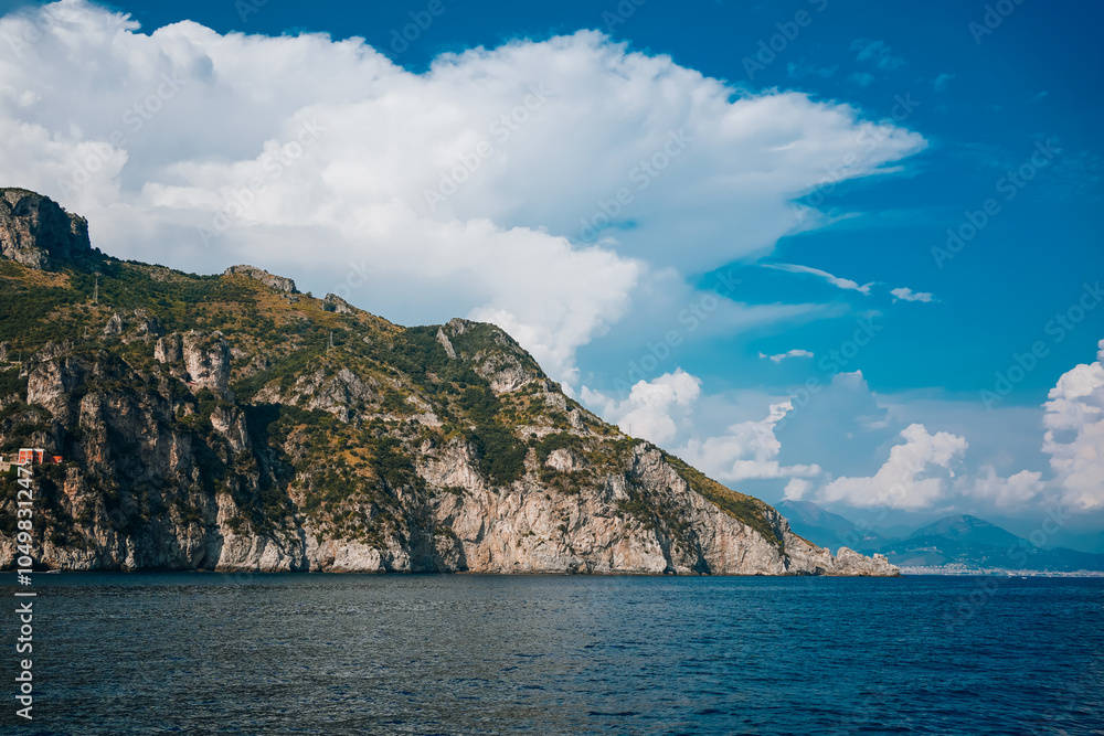 Panoramic view of Amalfi Coast from the sea with clear blue sky, mountains, and coastal buildings. Sunny summer day showcasing scenic landscape, cliffs, and tranquil Mediterranean waters.. Panoramic view of Amalfi Coast from the sea with clear blue sky, mountains, and coastal buildings. Sunny summer day showcasing scenic landscape, cliffs, and tranquil Mediterranean waters..