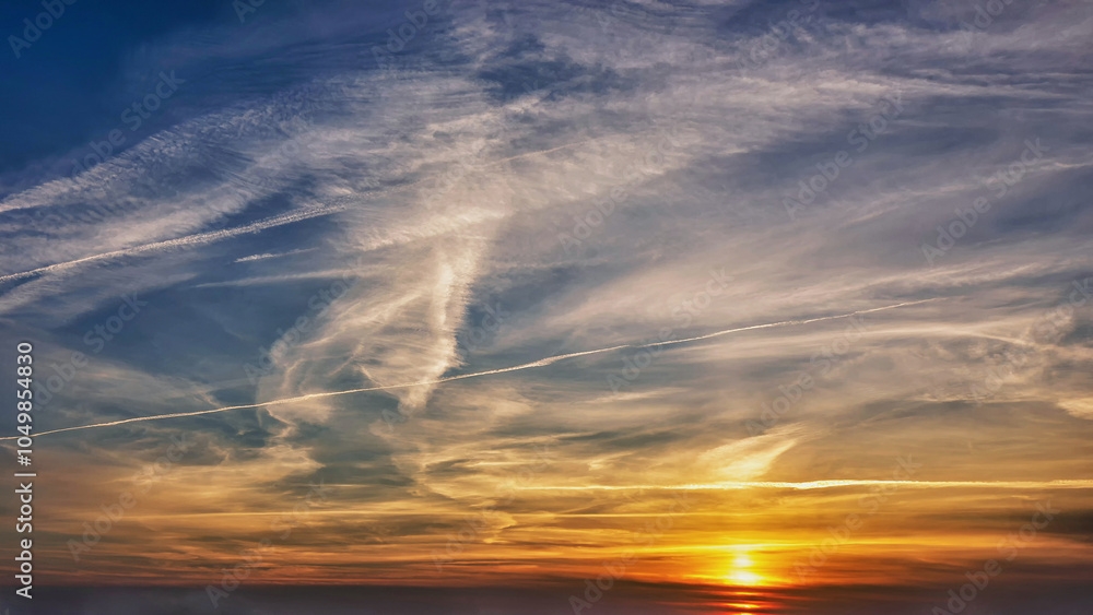 Fototapeta premium Sunset with vivid sky colors casting a warm golden glow on the horizon in the evening hours