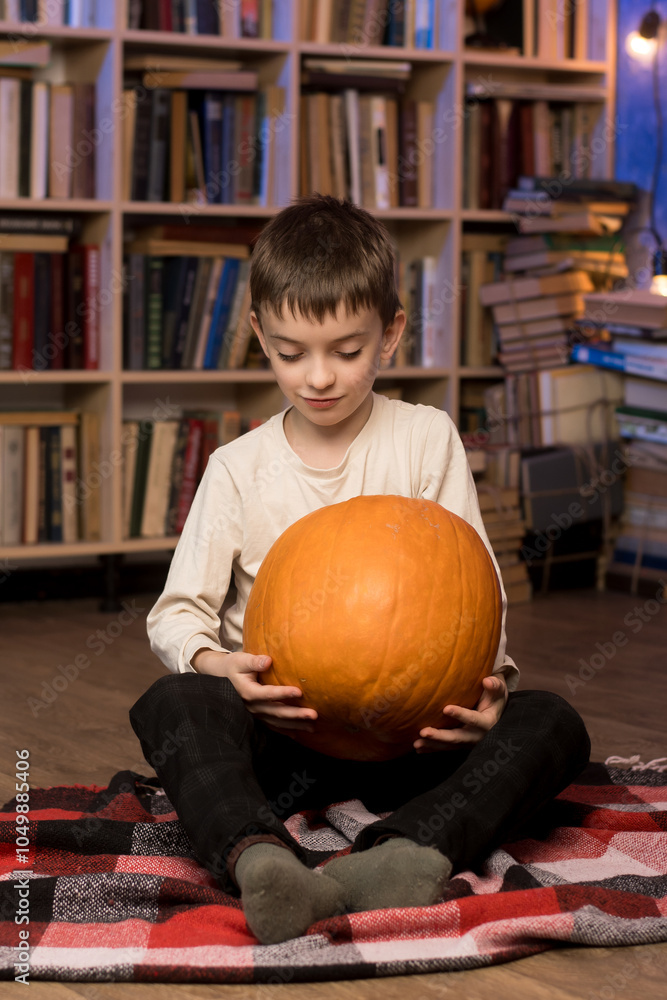 Fototapeta premium Young boy with pumpkins in a library, creating a cozy fall atmosphere. Perfect for seasonal content.