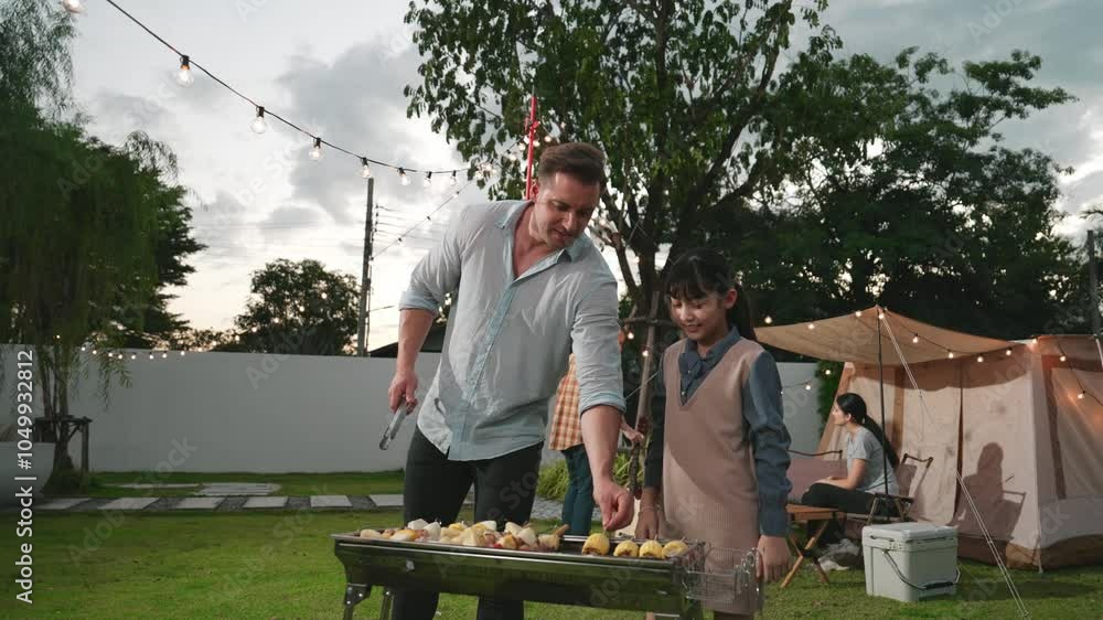 Family together camp in garden, father and daughter grill food for family member. Outdoor camping activity to relax with nature and spend time with young generation cross generation gap. Divergence. Family together camp in garden, father and daughter grill food for family member. Outdoor camping activity to relax with nature and spend time with young generation cross generation gap. Divergence.