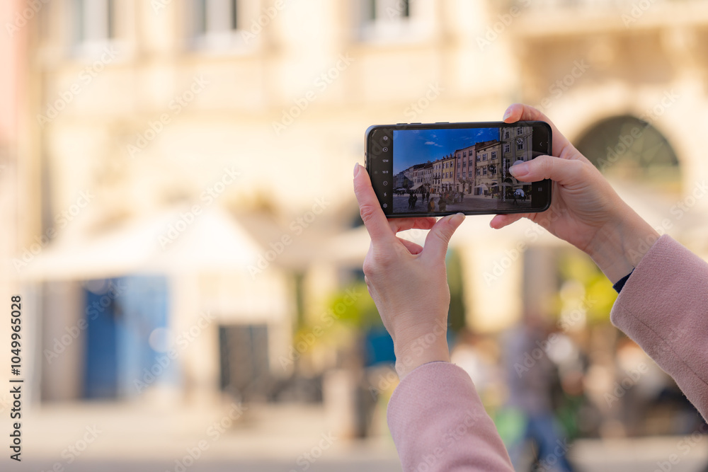 Female hands holding smartphone and making photos in Lviv