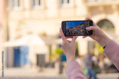 Obraz na płótnie Female hands holding smartphone and making photos in Lviv w salonie