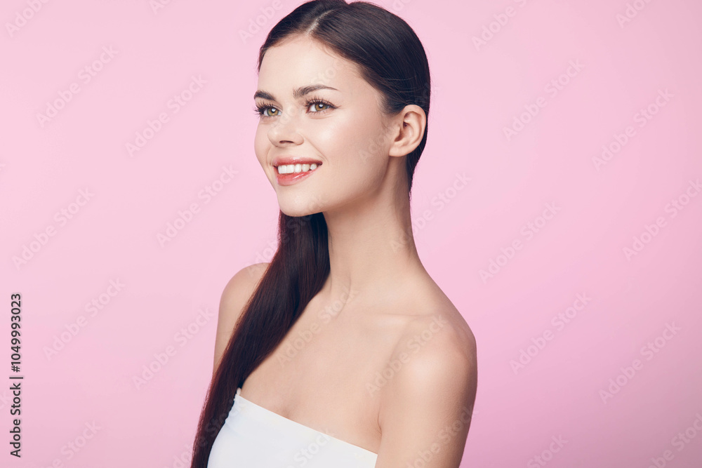 Beautiful young woman with long straight hair posing on a pink background in a reklamní fotografie image licence Beautiful young woman with long straight hair posing on a pink background in a reklamní fotografie image licence