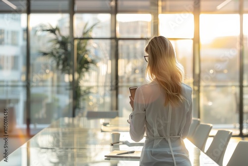 A woman stands in a sunlit office with a phone in hand, gazing towards an expansive cityscape through large windows, a scene embodying connectivity and opportunity. Free Download A woman stands in a sunlit office with a phone in hand, gazing towards an expansive cityscape through large windows, a scene embodying connectivity and opportunity. - GFXLoad