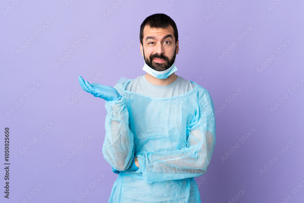 Surgeon man with beard with blue uniform over isolated purple background having doubts Surgeon man with beard with blue uniform over isolated purple background having doubts