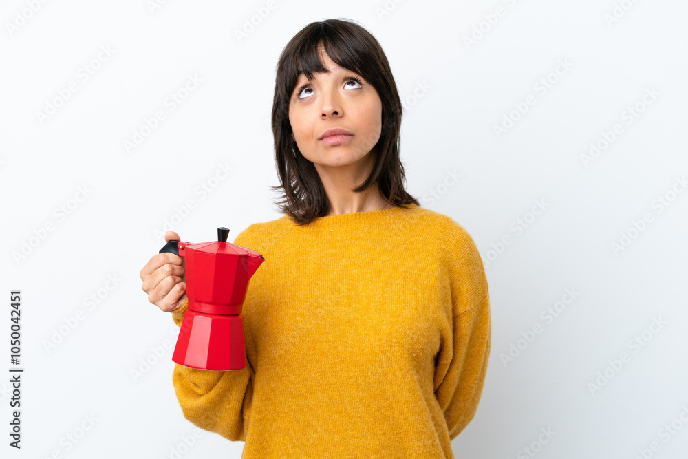 Young mixed race woman holding coffee pot isolated on white background and looking up Young mixed race woman holding coffee pot isolated on white background and looking up