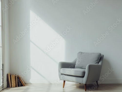 Gray chair sits in a room with a white wall and a window. The chair is empty and the room is uncluttered photo