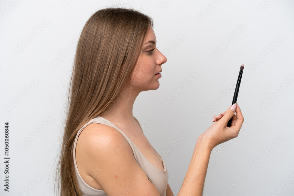Young Lithuanian woman isolated on white background holding makeup brush Young Lithuanian woman isolated on white background holding makeup brush