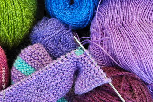 A knitting in progress, surrounded by vibrant threads and essential tools. The concept of crafting, DIY, or textile themes.