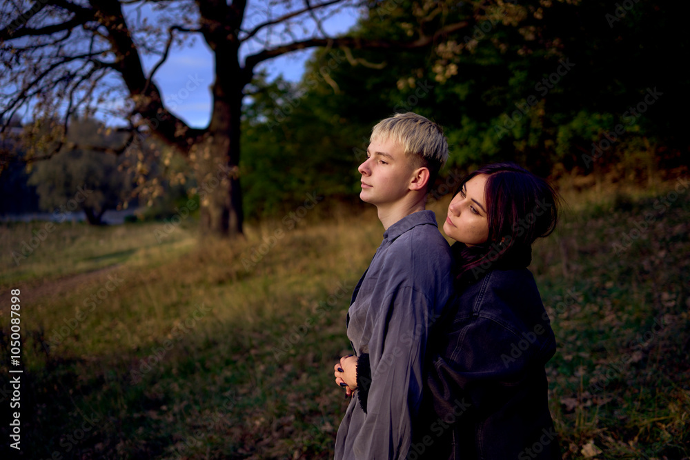 Fototapeta premium two 15-year-old teenagers in love play, hug, spend time together in an autumn park