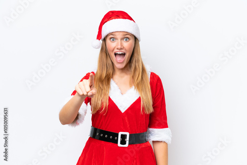 Young caucasian woman dressed as mama noel isolated on white background surprised and pointing front