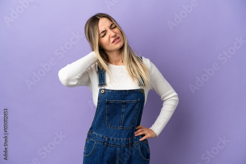 Young woman over isolated purple background with neckache photo