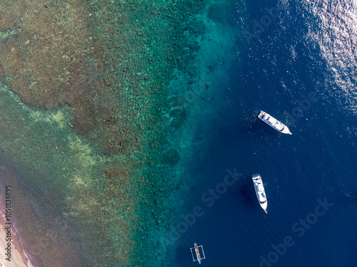 Aerial view of boats floating near a vibrant coral reef. photo