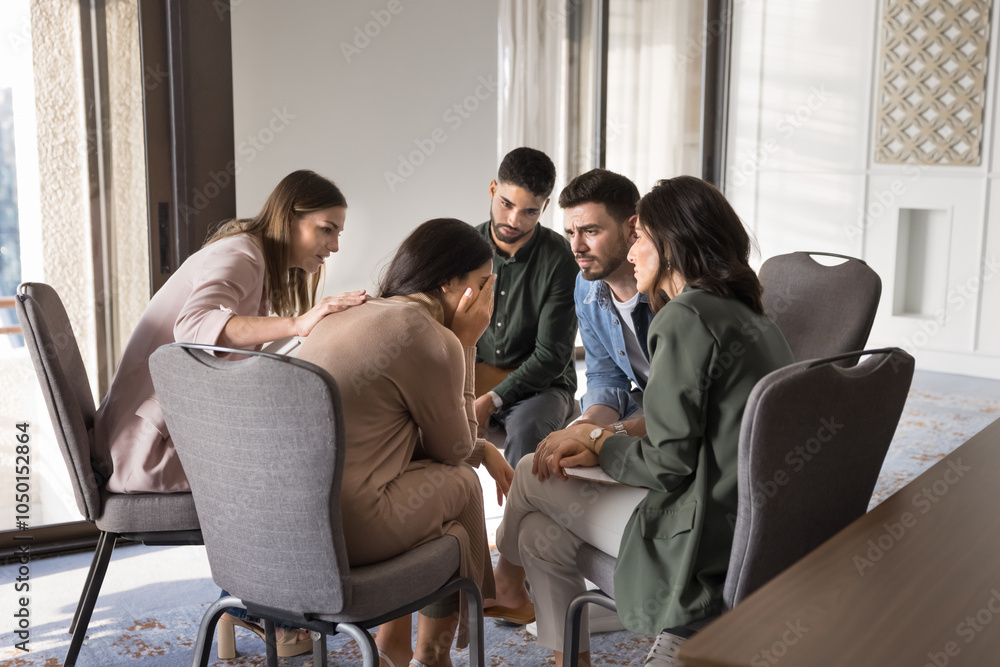 Diverse patients meeting for group therapy, community support, discussing problems. Multiethnic team comforting crying young Latin woman, giving empathy, sitting in circle Diverse patients meeting for group therapy, community support, discussing problems. Multiethnic team comforting crying young Latin woman, giving empathy, sitting in circle