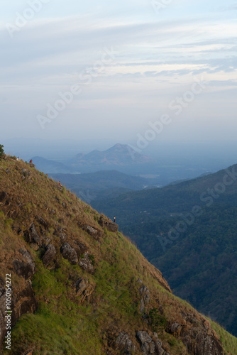 A lone hiker enjoys the scenic mountain view at dusk.