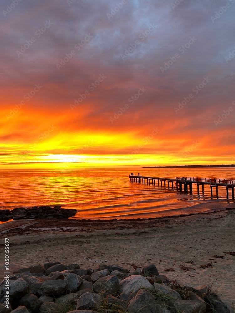 People on the pier in watching sunset in Southern Sweden in Angelholm