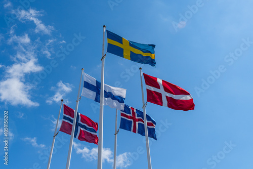 Obraz na płótnie Scandinavian countries flags waving on metal poles against blue sky. w salonie