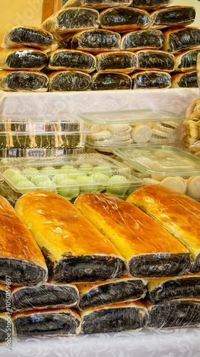 Assorted traditional Filipino breads and rice cakes neatly stacked on display at a local market, highlighting cultural diversity and culinary tradition photo